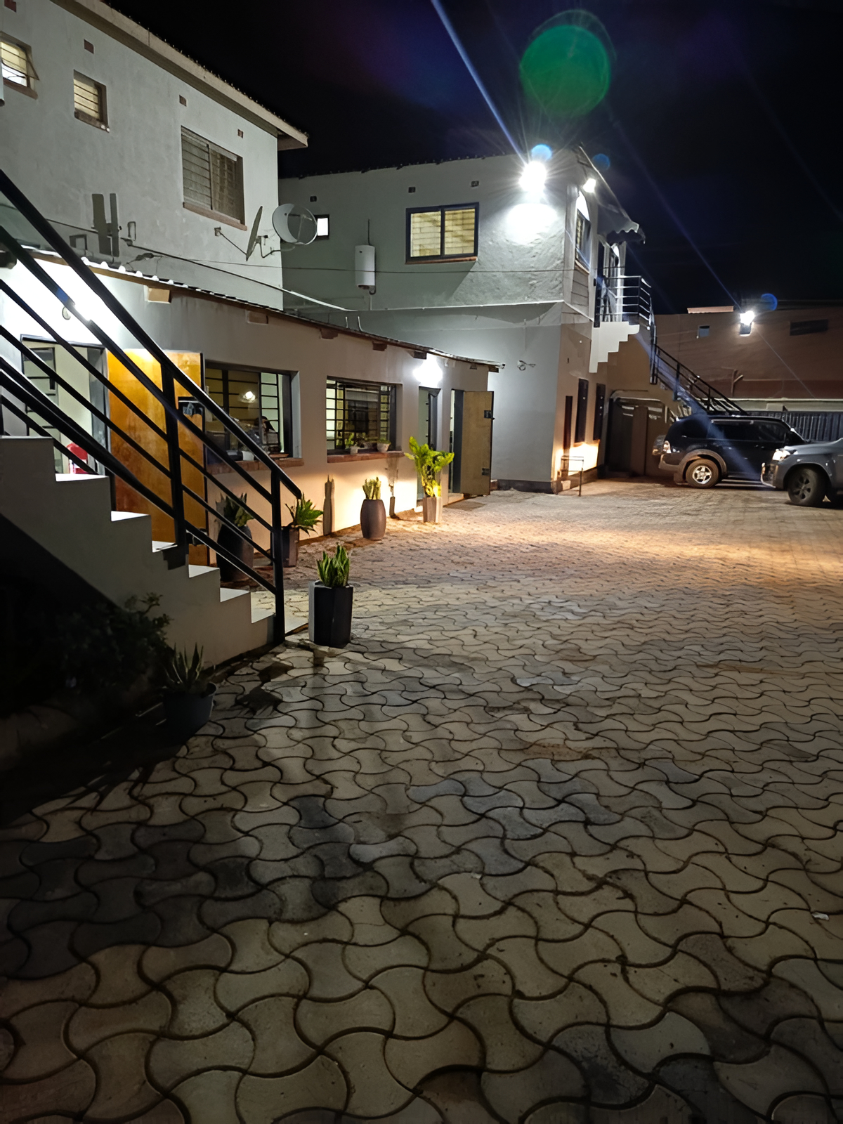 Rosmon Guest Lodge at dusk, warmly lit entrance and garden